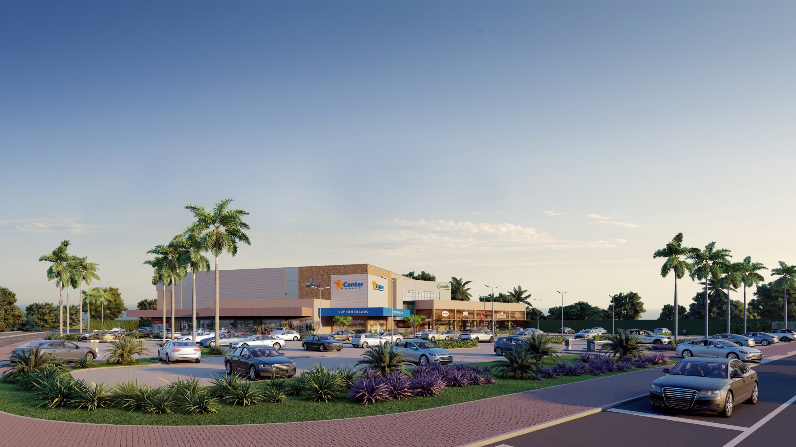 Vita Park Mall visto da avenida ao amanhecer, com palmeiras, jardins e o estacionamento em frente às lojas